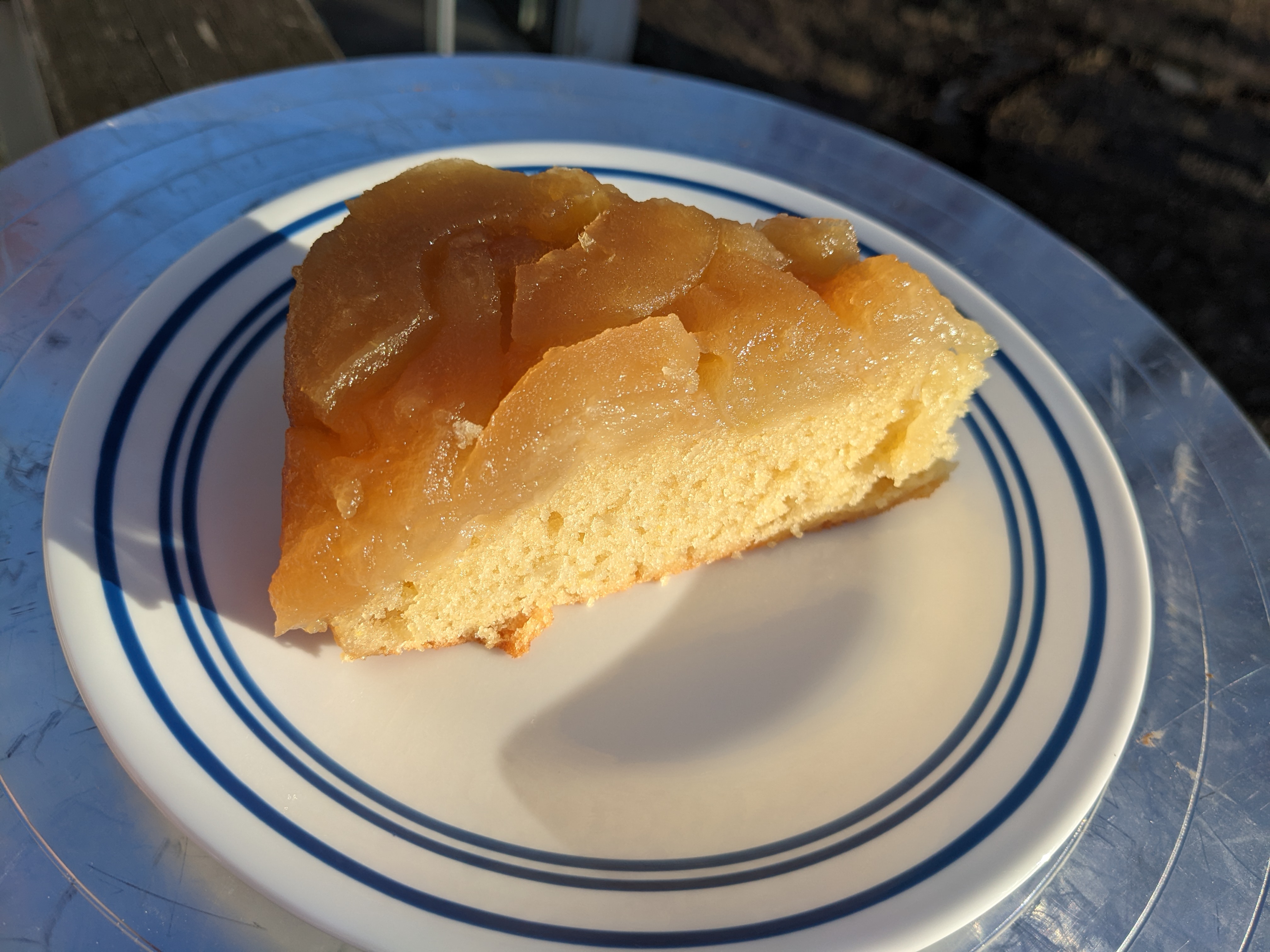A slice of yellow cake with cooked apples on top