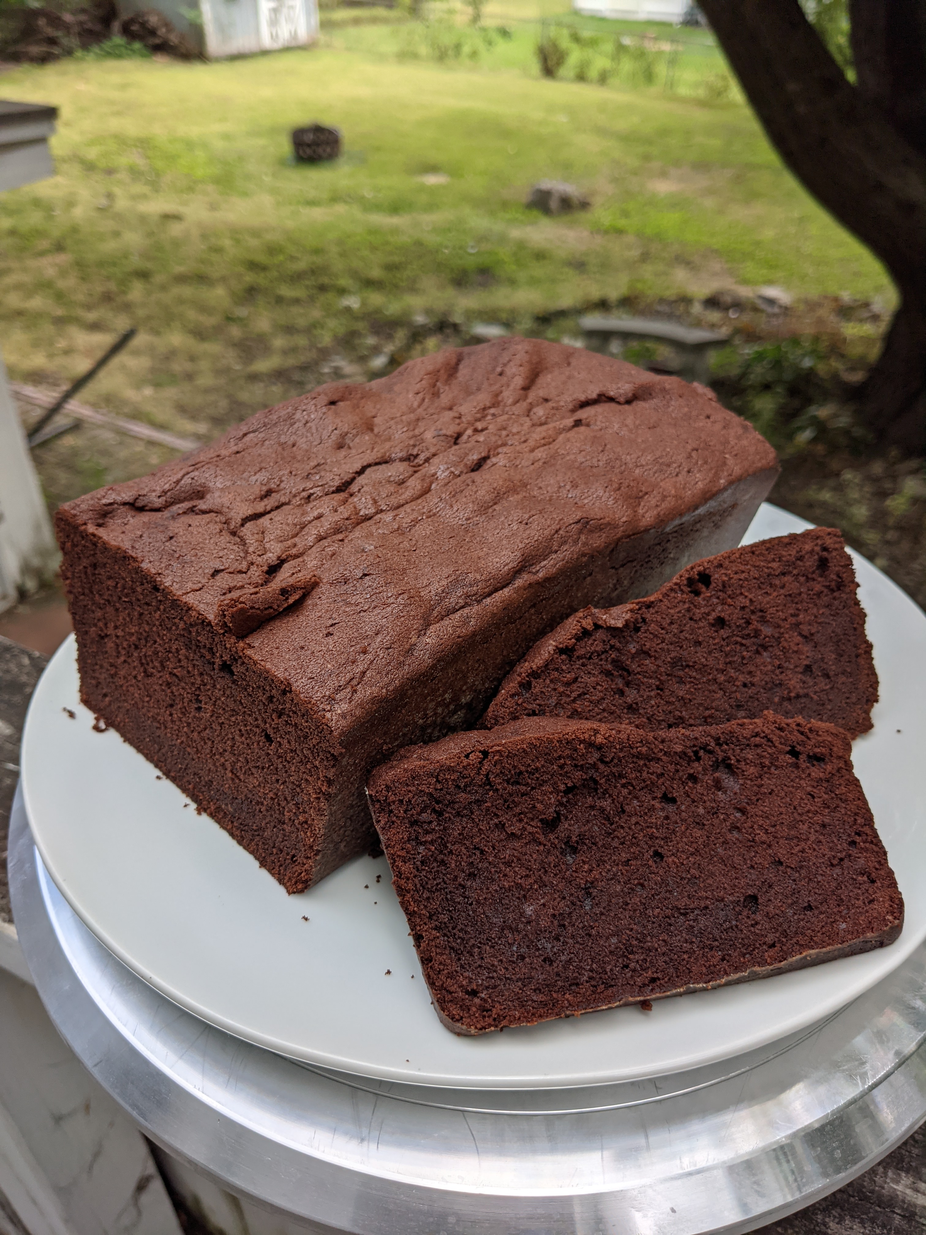 A loaf of chocolate pound cake with two slices