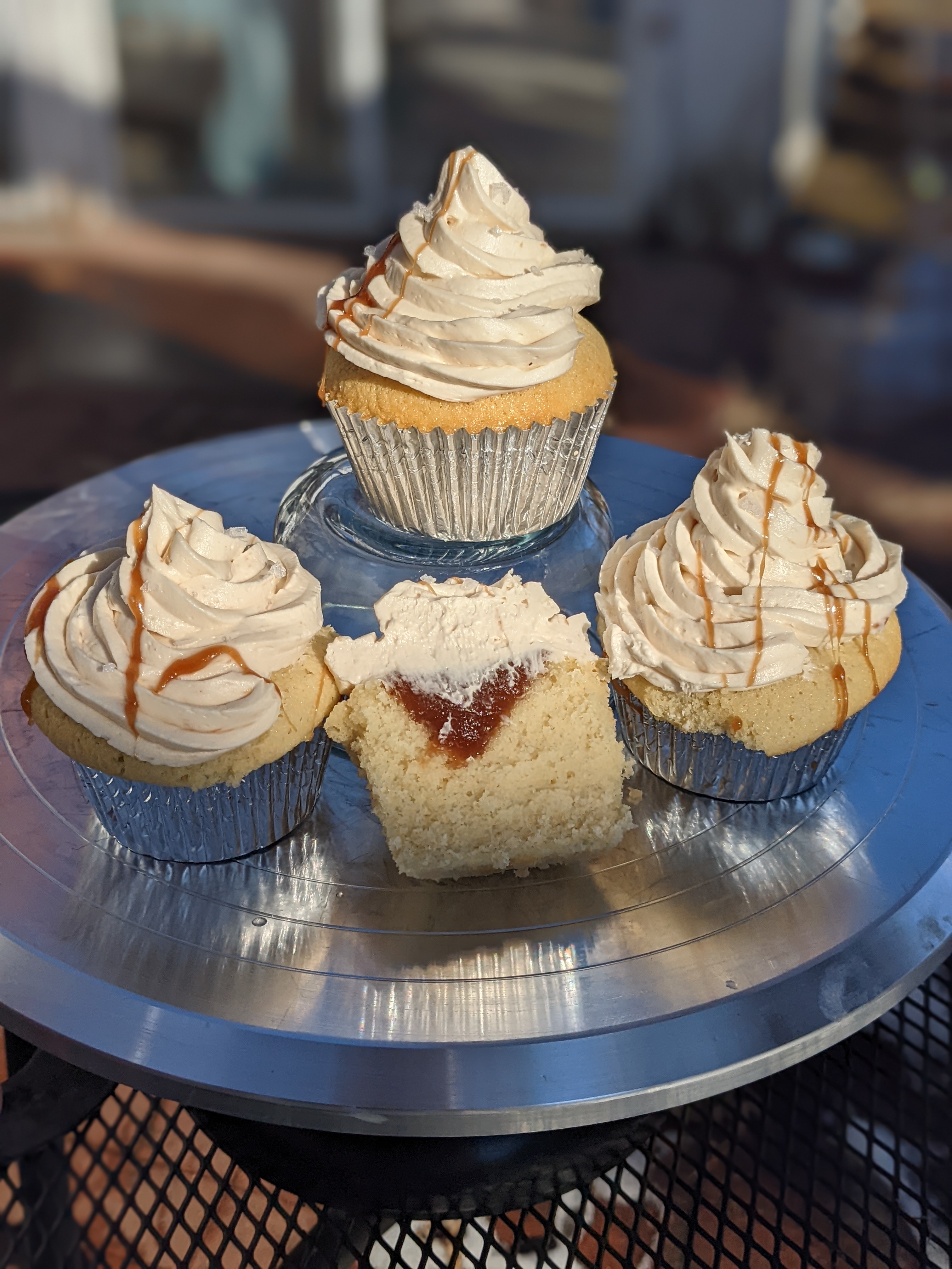Three and a half cupcakes with light yellow frosting. Each drizzled with golden caramel.